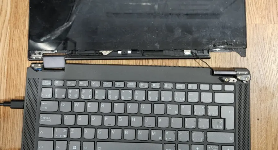 Lenovo laptop with a damaged hinge and partially detached display